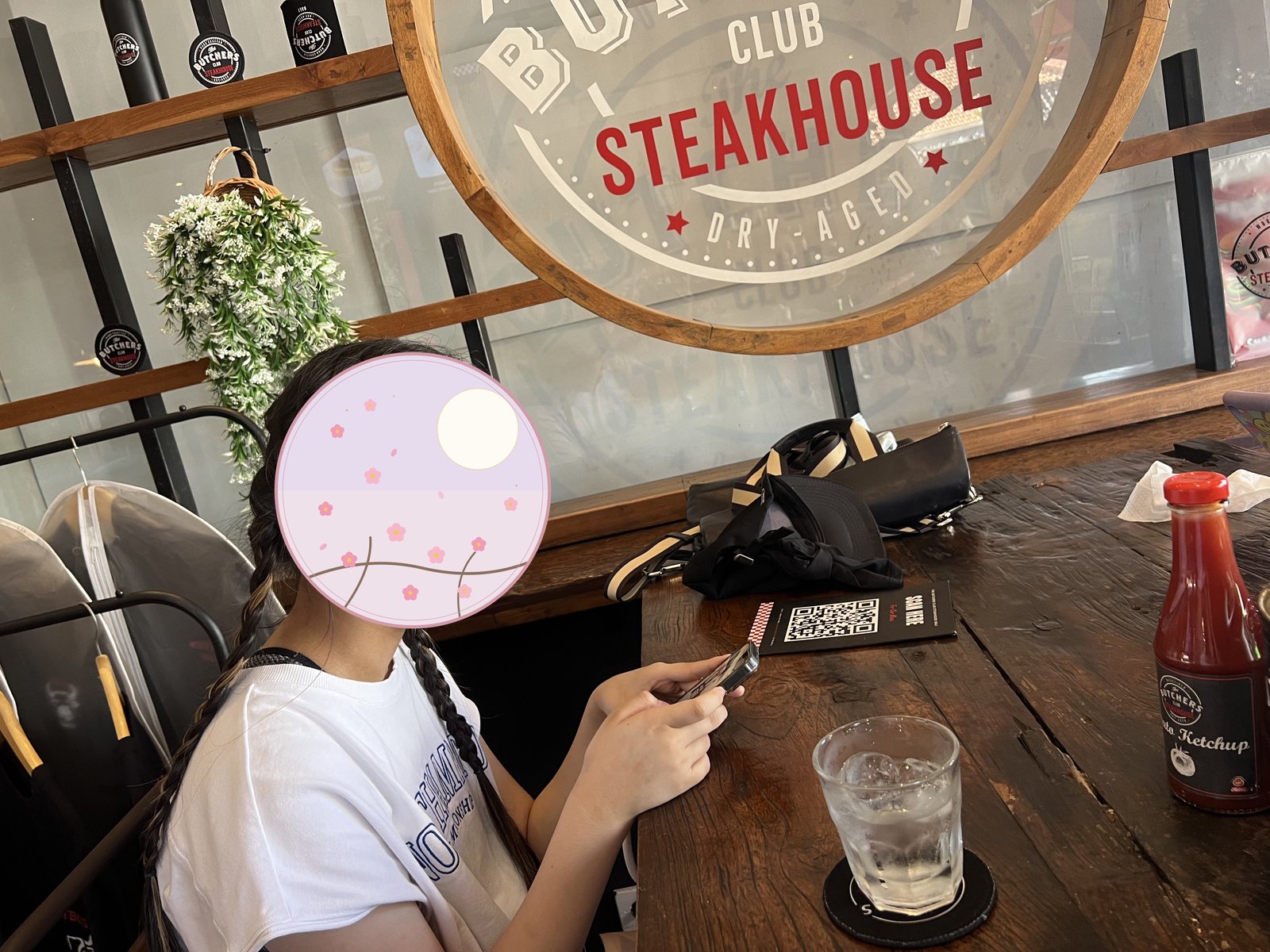 ステーキハウスの看板と食事の準備をする子ども