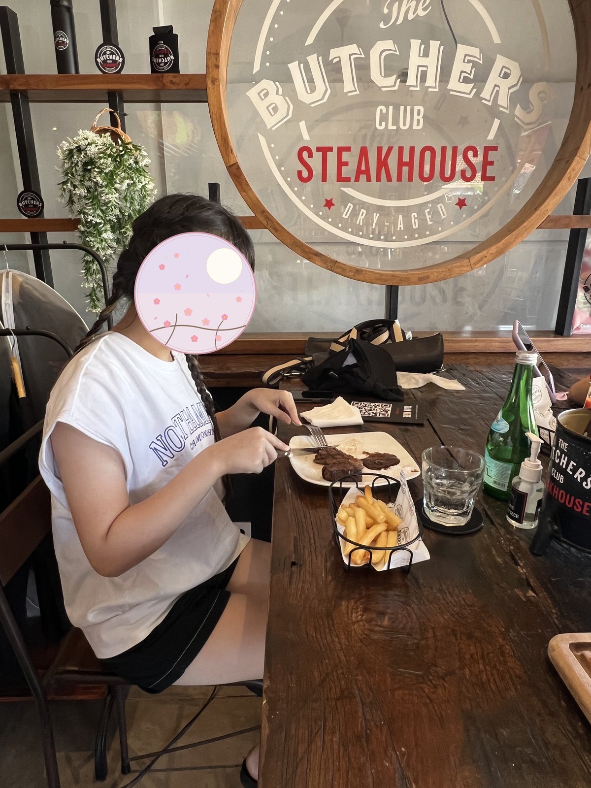ステーキとフライドポテトを前に食事する子ども