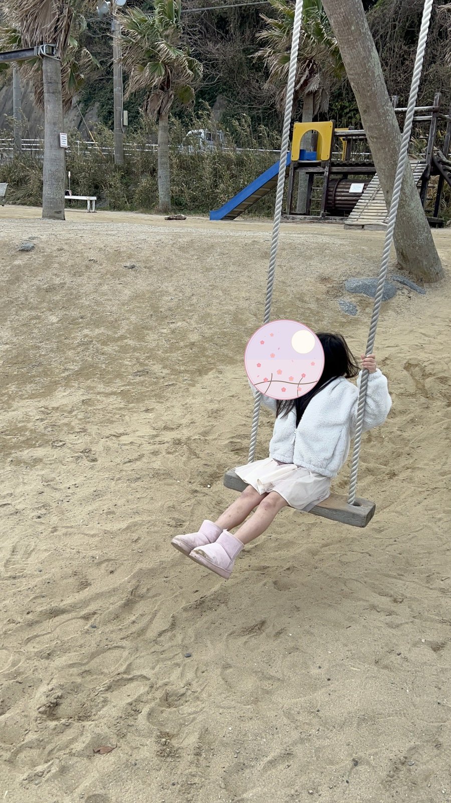 見上げるヤシの木ブランコと娘
