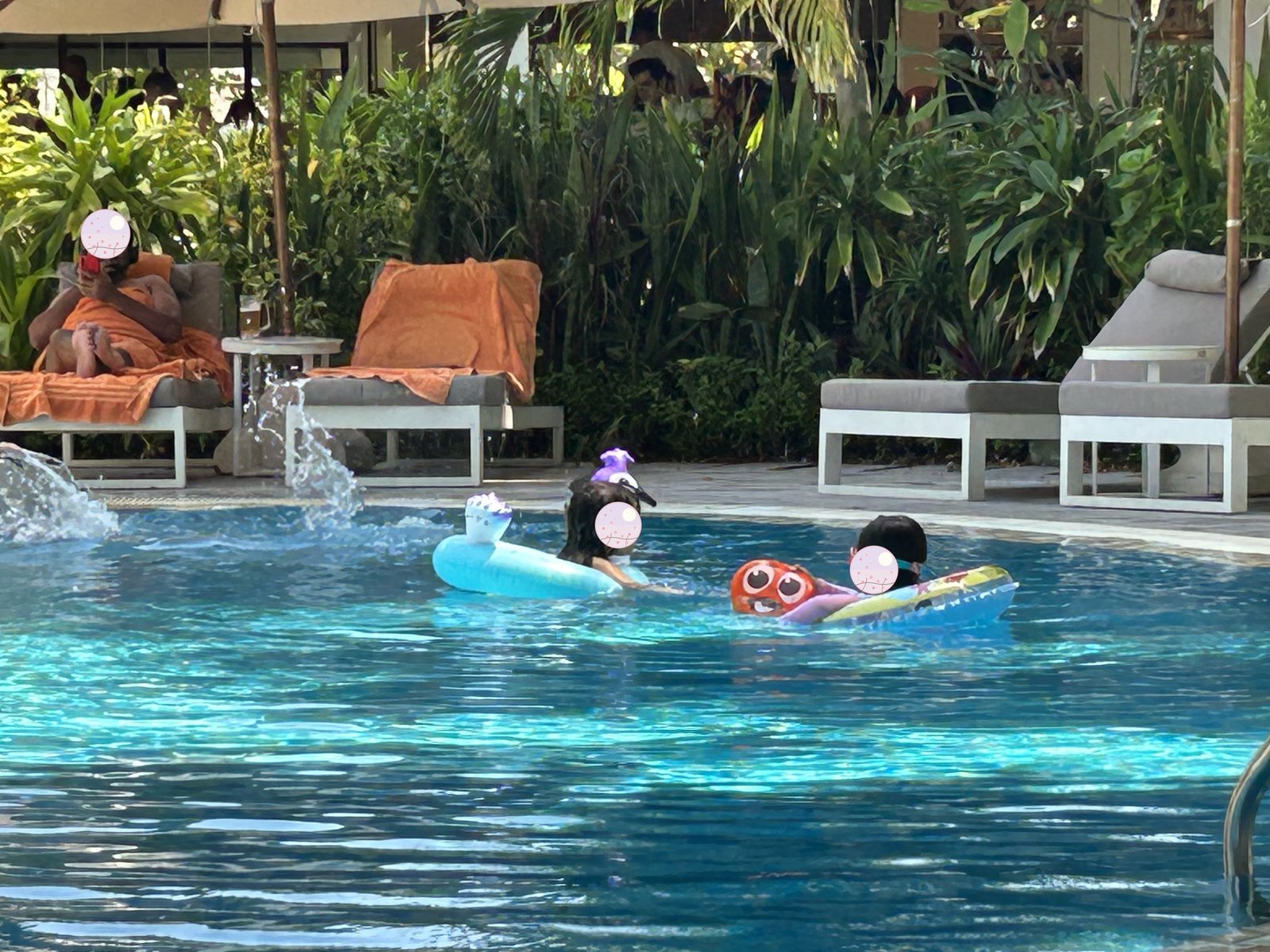 プールで浮き輪に乗って遊ぶ子どもたち