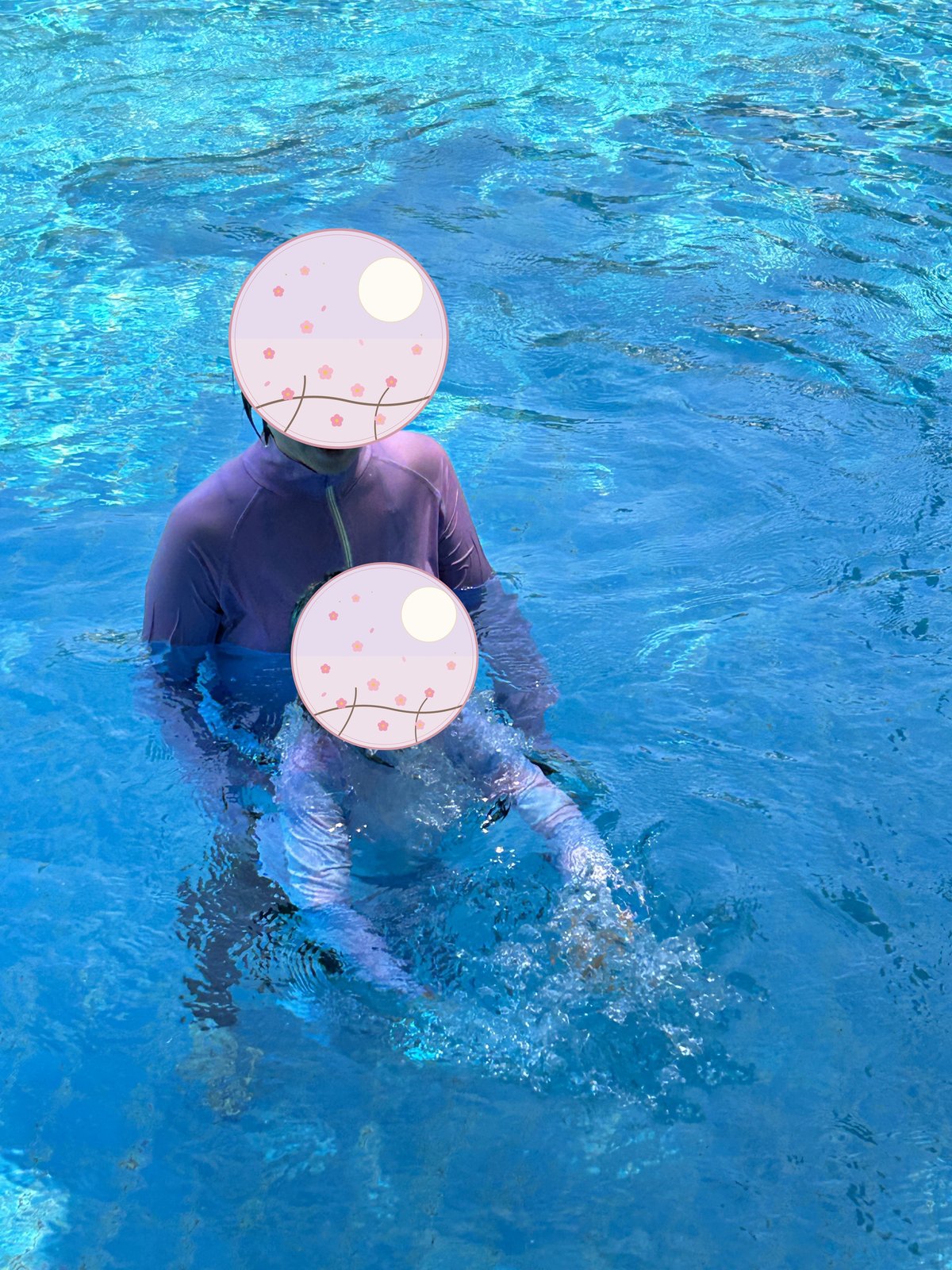 ピンクのゴーグルをつけてプールで泳ぐ子ども