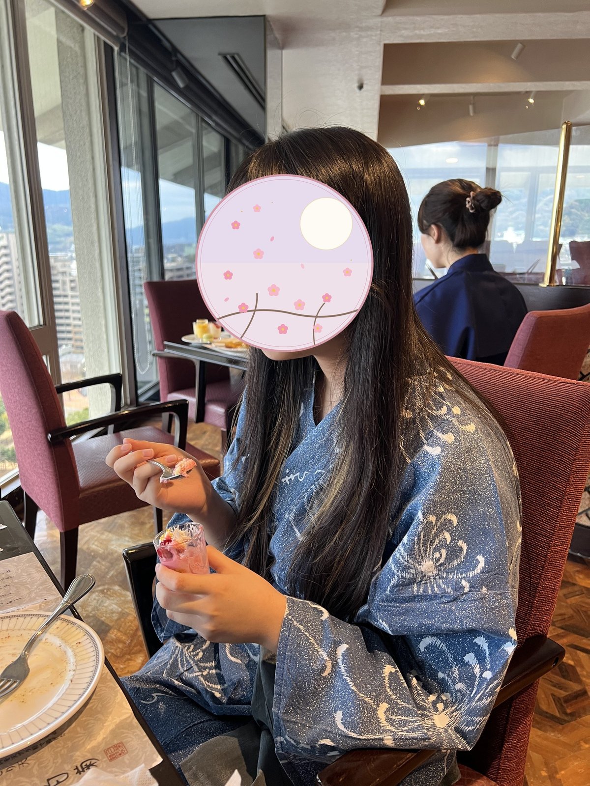 窓の外に別府の街を望みながらデザートを楽しむ子ども