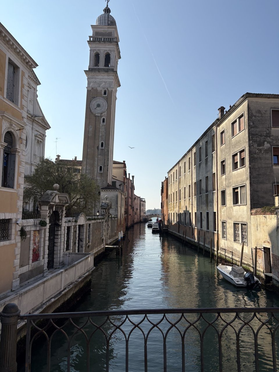 A canal with a leaning bell tower